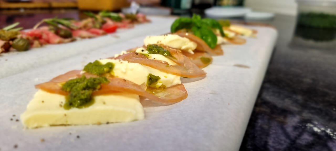 Mozzarella and cured meat with pesto, prepared on the pass