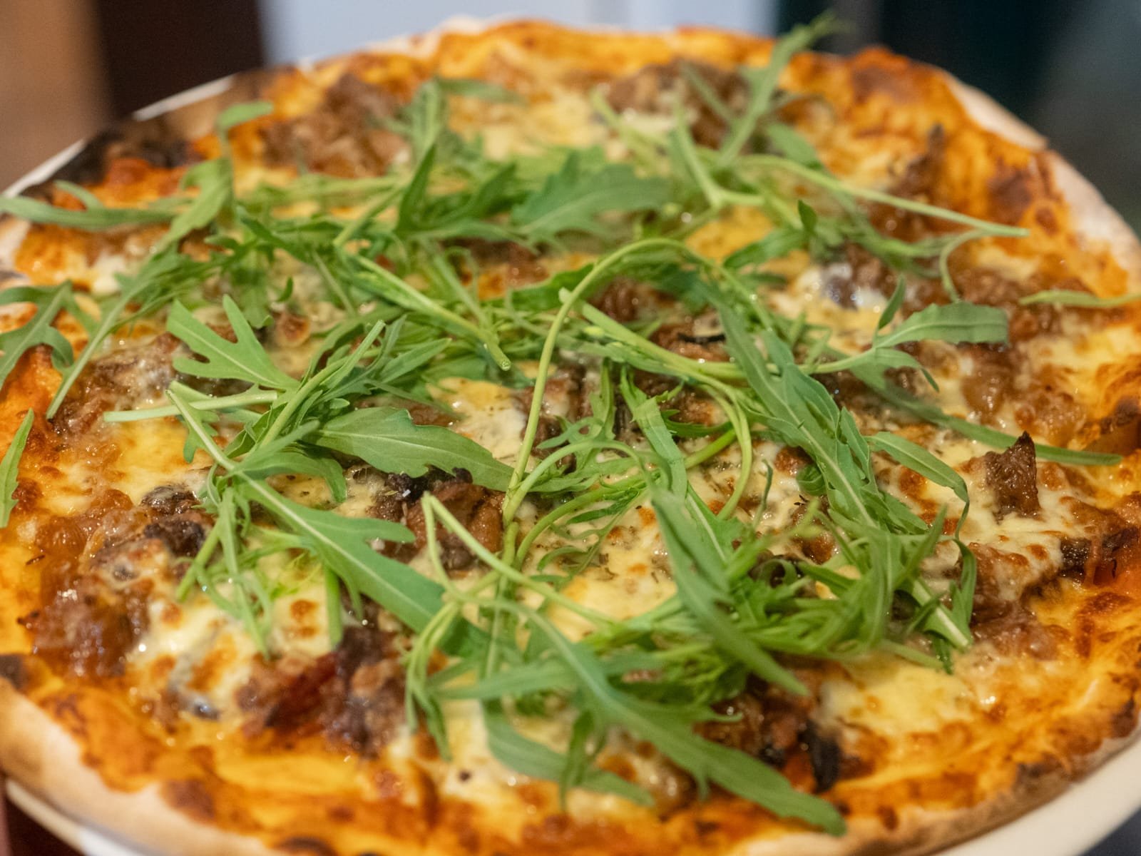 Wood-fired pizza topped with fresh rocket