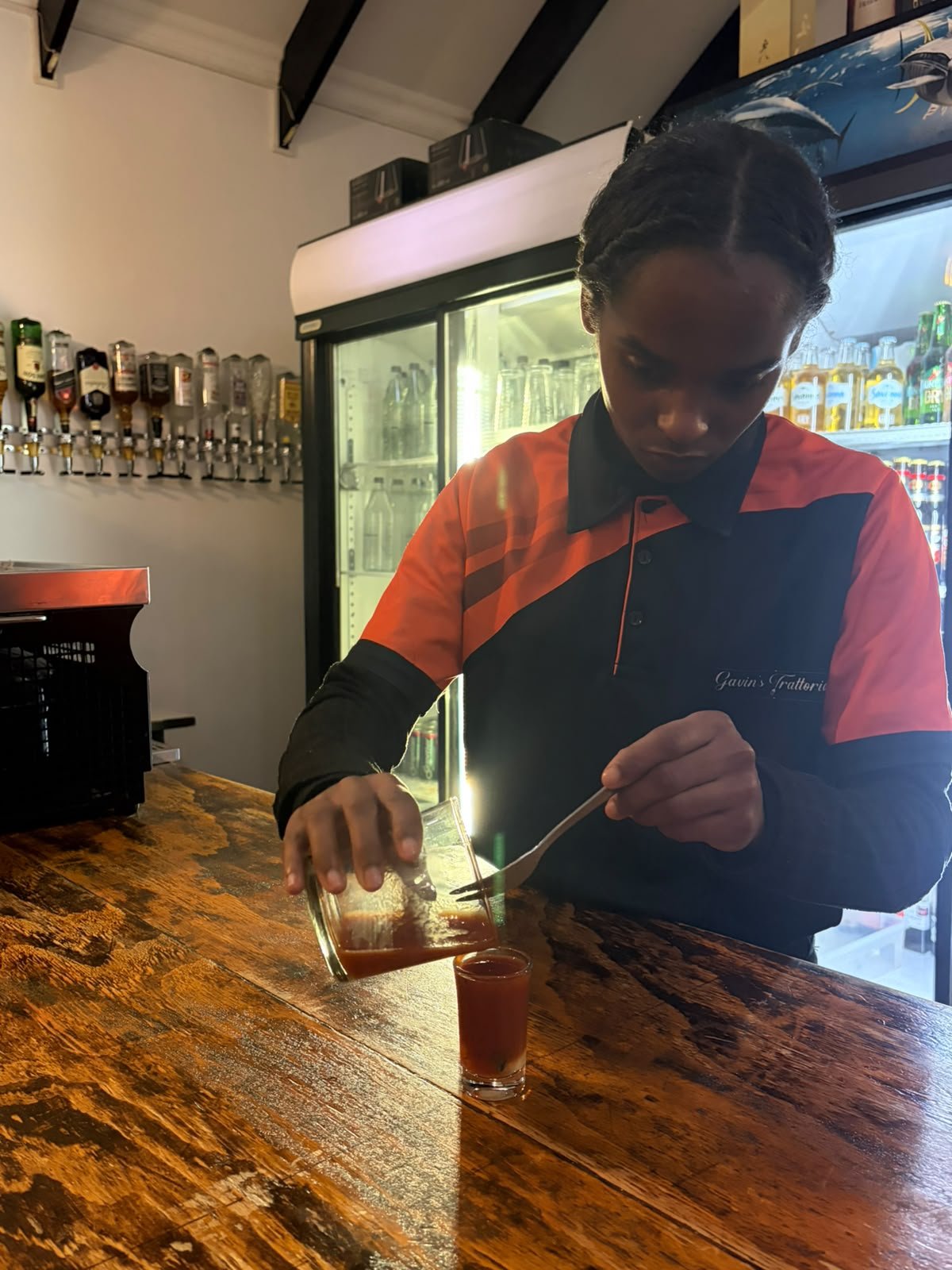 A staff member pouring a house-made shooter at the bar