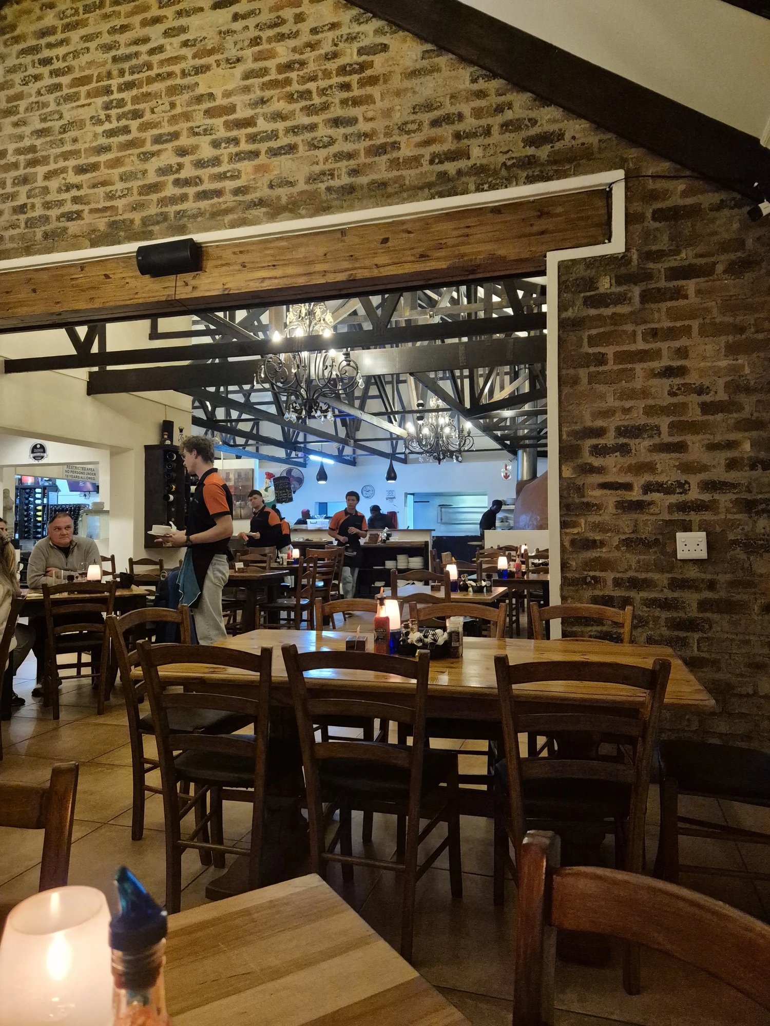 Staff setting a table in the dining room beneath the chandeliers