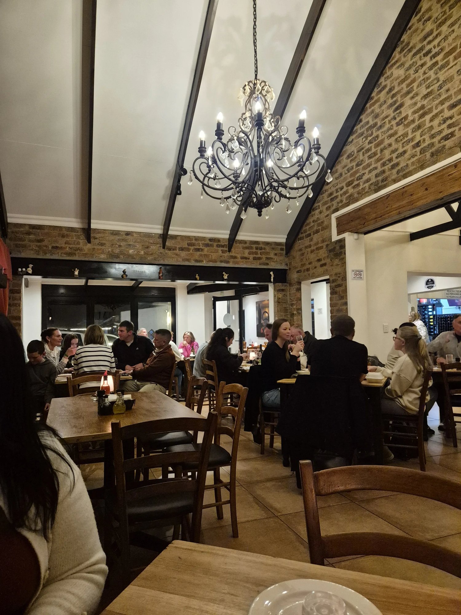 A full dining room of guests sharing tables at Gavin's Trattoria